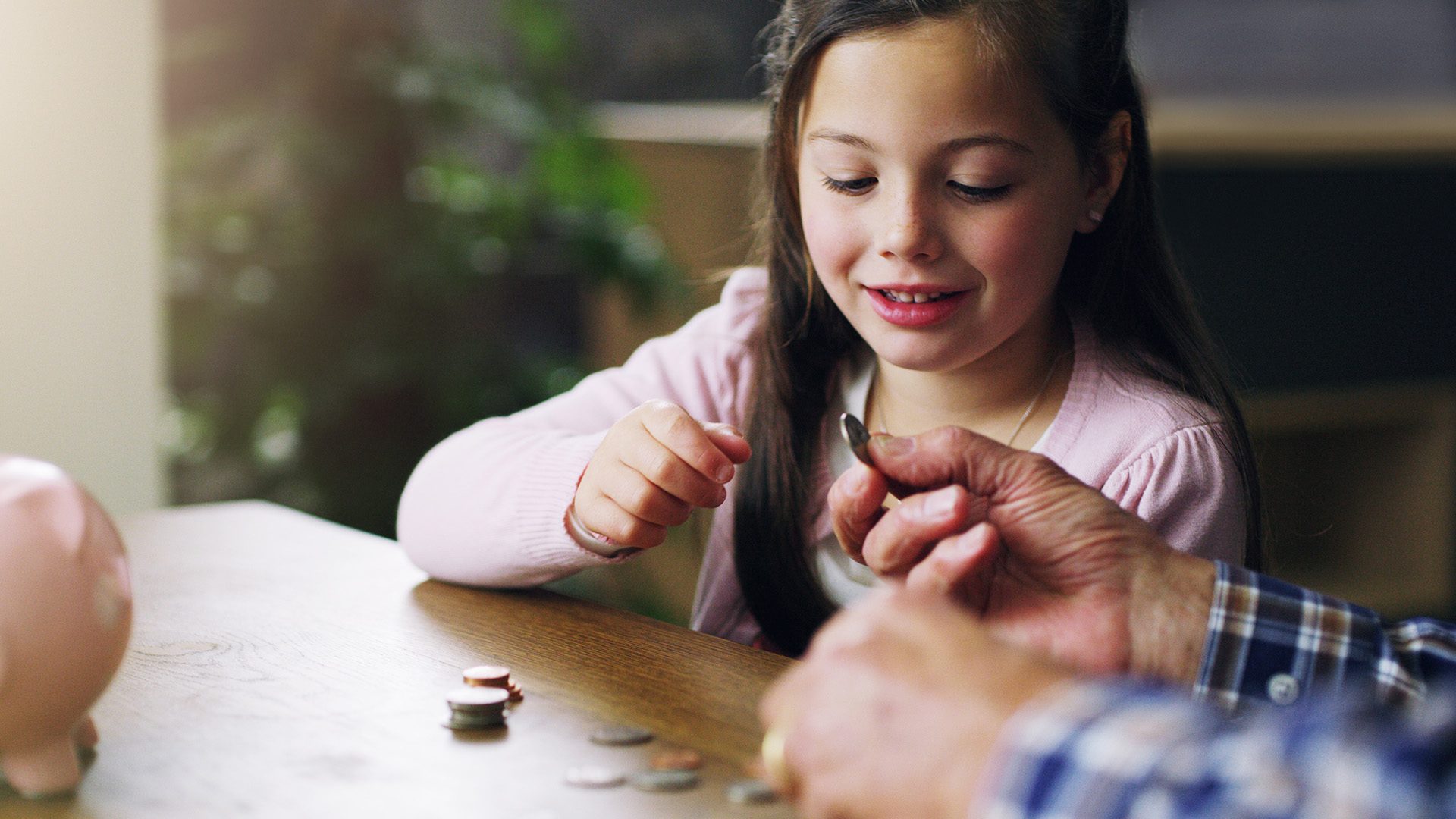 Shot of a little girl learning about money from her grandfather